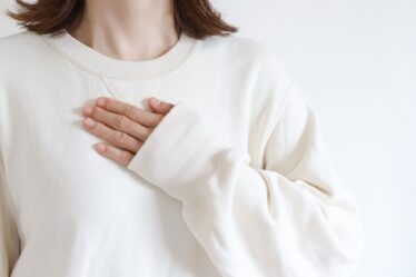 女性　胸に手を当てる